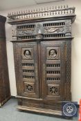 A 19th century carved oak double door cabinet fitted with a drawer,