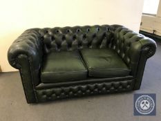 A green buttoned leather Chesterfield style two seater settee,