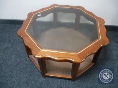 A contemporary octagonal glass topped coffee table with under shelf