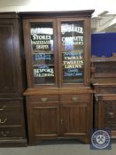 A Victorian and later glazed mahogany bookcase with later advertising writing,
