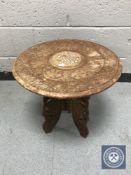 A carved Eastern folding occasional table