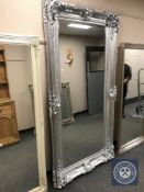 An ornate silvered bevelled floor standing mirror,
