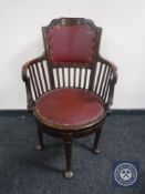 A Victorian mahogany revolving desk chair upholstered in Burgundy leather on club feet