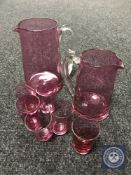 Two early 20th century cranberry glass jugs together with six small beakers