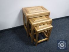 A nest of three oriental style carved pine tables