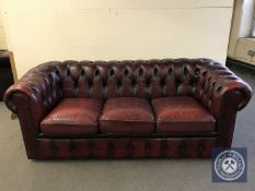 A red button leather three seater club settee