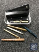 A tub containing a collection of fountain and ball point pens