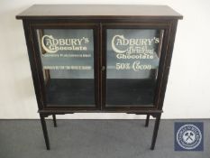 A Victorian inlaid glazed door cabinet bearing Cadbury's advertising