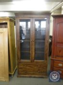A hardwood glazed door bookcase fitted two drawers