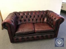 A red button leather two seater club settee