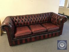 A red button leather three seater club settee