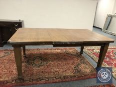 An Edwardian oak extending dining table,