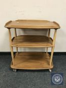 An Ercol elm three tier serving trolley, width 71 cm.