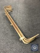 An early 20th century brass fender on paw feet