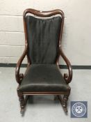 A Victorian mahogany scroll arm rocking chair