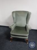 A twentieth century wingback armchair upholstered in green dralon