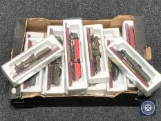 A box containing seventeen die cast model locomotives on wooden stands