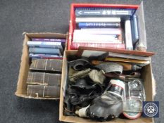A box containing militaria to include WWII gas mask, webbing belts, glass desk stand,