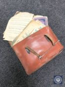 A vintage leather satchel containing sheet music