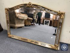 A decorative gilt framed shaped topped overmantel mirror