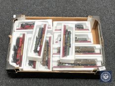 A box containing eighteen die cast model locomotives on wooden stands