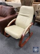 A wood framed cream leather rocking chair