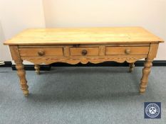 A pine farmhouse kitchen table fitted three drawers
