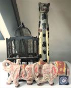 A wood and wire metal bid cage together with two wooden figures of an elephant and a cat
