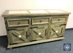 A pine triple door sideboard with travertine inset tiles