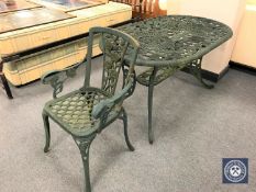 An oval cast metal garden table and an armchair