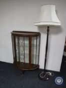A mid 20th century walnut d-shaped display cabinet and a standard lamp