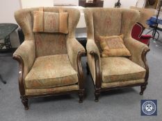 A pair of Victorian style scroll arm wing armchairs