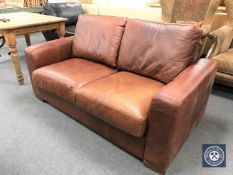 A brown leather two seater settee