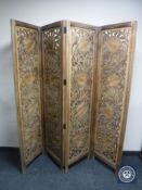 A carved hardwood four-way room divider