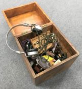 An early 20th century wooden box containing vintage radio parts, vintage headphones etc.