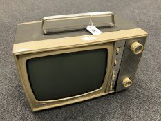 A Stella portable TV set in two tone silvered and cream coloured case.