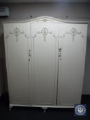 A cream and gilt triple door wardrobe
