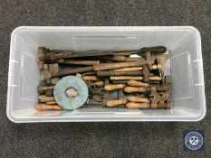 A plastic tub of hand tools including hammers, saws,
