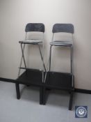 A pair of folding bar stools and two black ash occasional tables