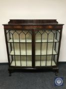 A mahogany display cabinet on claw and ball feet