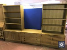 A blonde oak twin section bookcase fitted with cupboards beneath together with a similar four