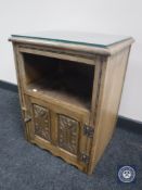 A carved oak glass topped bedside cabinet