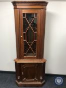 A reproduction glazed door corner cabinet