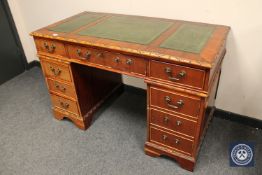 A reproduction twin pedestal writing desk with tooled leather top,
