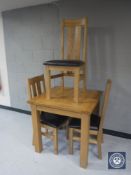 An oak dining table with three chairs