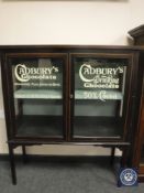 A Victorian and later inlaid mahogany display cabinet with Cadburys advertising,