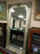 A large ornate silvered overmantel mirror, 200 cm x 100 cm.