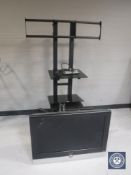 A Pristigio 32 inch LCD TV with lead and remote with portable audio stand