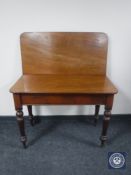 A Victorian mahogany foldover tea table