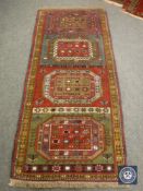 A Persian fringed rug of multi coloured geometric design,